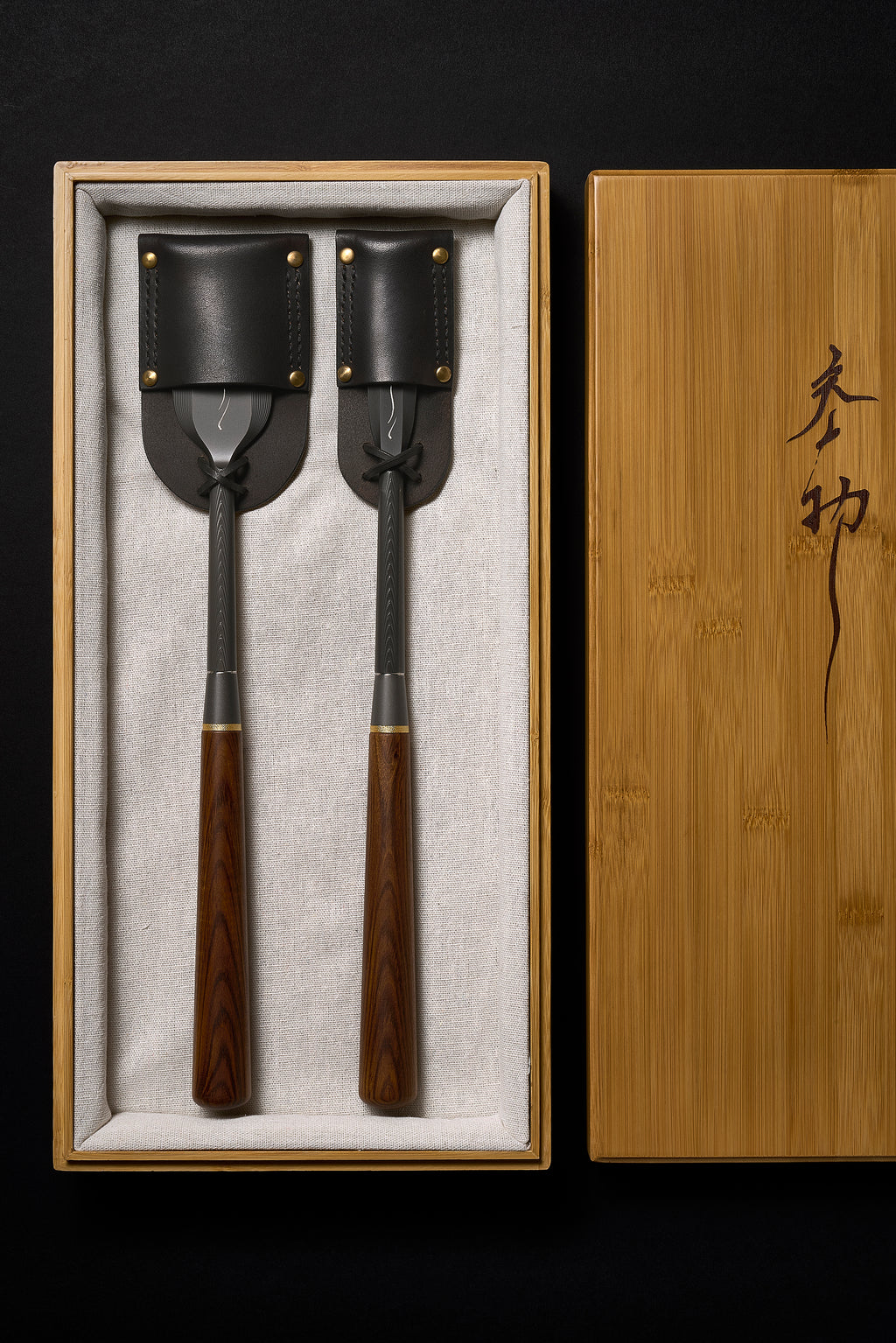 The DC-1 paring chisel pair in its bamboo box with stitched leather blade guards tied on, lid alongside