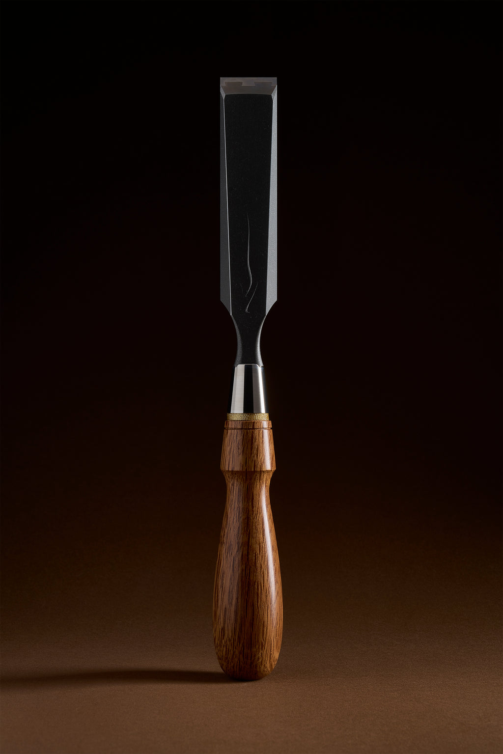 Widest X-2 bench chisel upright, black titanium body and polished steel face, red bamboo-leaf oak handle