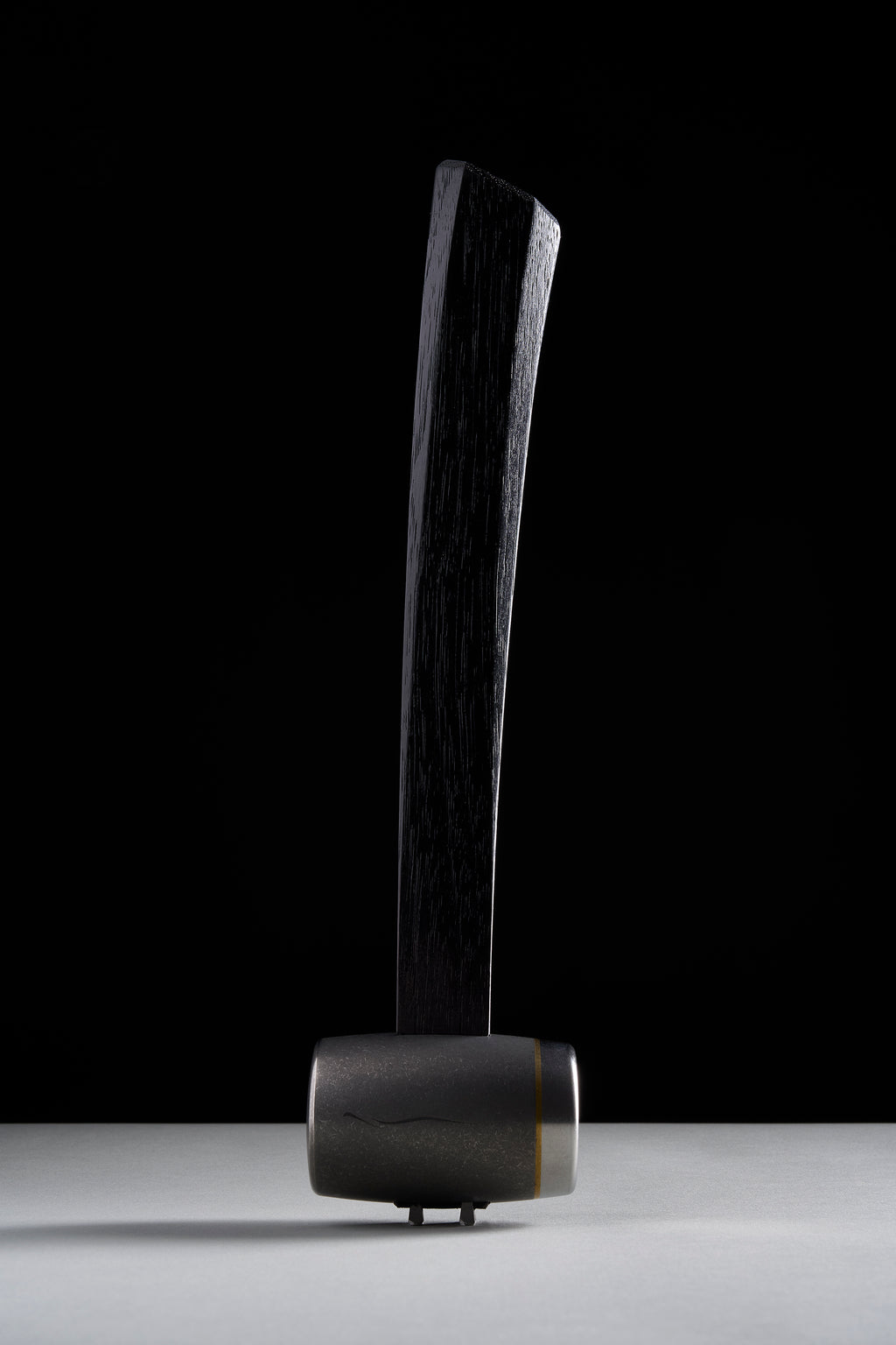 F-4 hammer with flame-anodized titanium head and brass ring, standing upright
