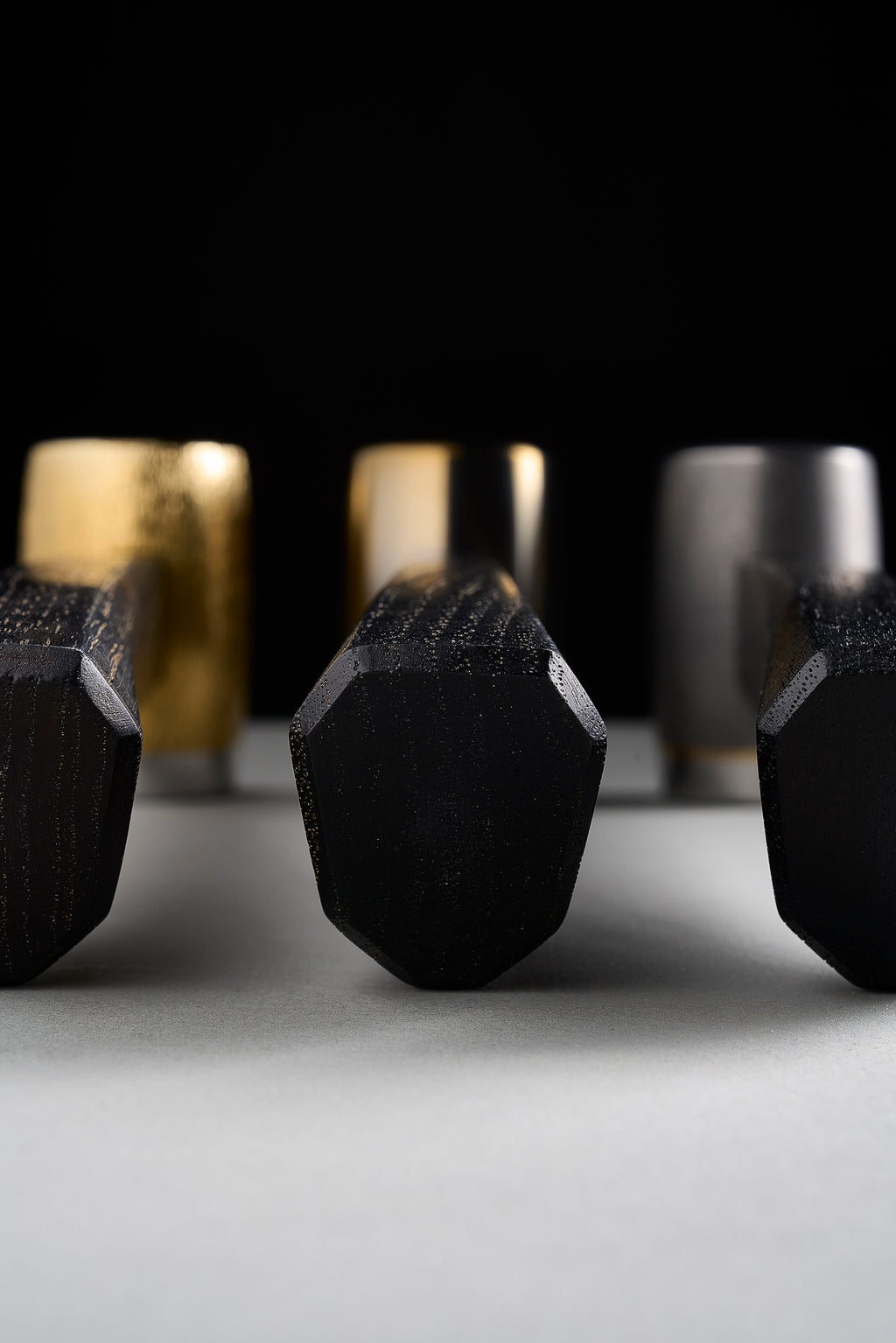 Octagonal faceted butt ends of three F-4 dyed hickory handles