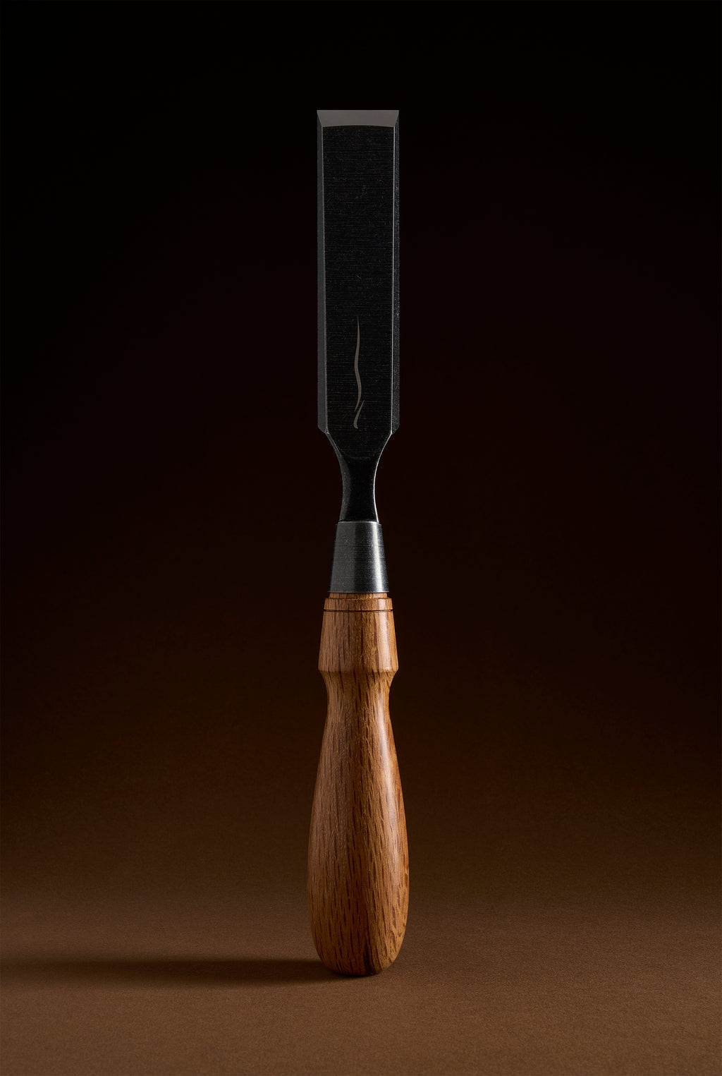 Y-2 bench chisel standing upright, wide dark blade above the steel ferrule and turned wooden handle