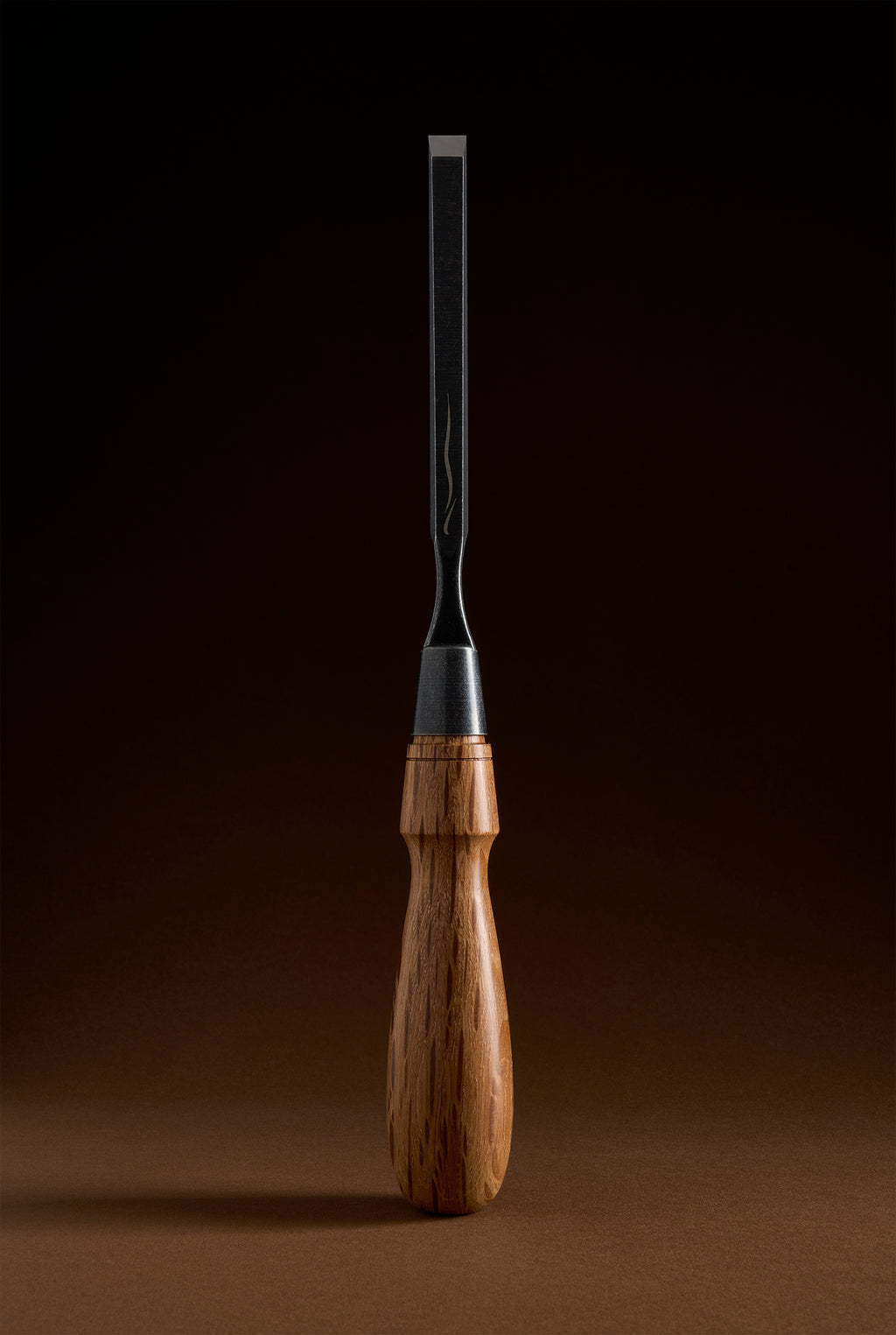 Narrow Y-2 chisel standing upright, slim dark blade meeting the steel ferrule and turned handle