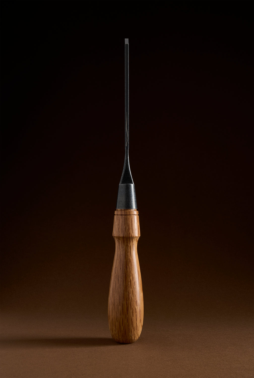 The narrowest Y-2 chisel upright, slender blade rising from the ferrule and wooden handle