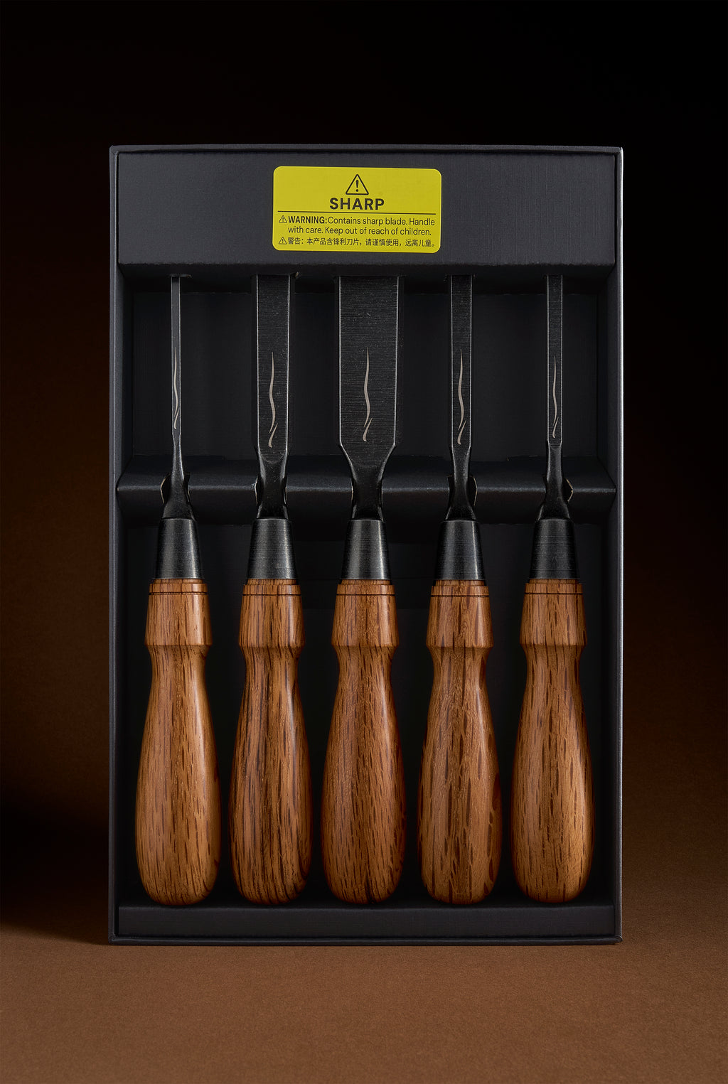 Five-chisel Y-2 set in its black box, blades up, with a yellow sharp-blade warning label