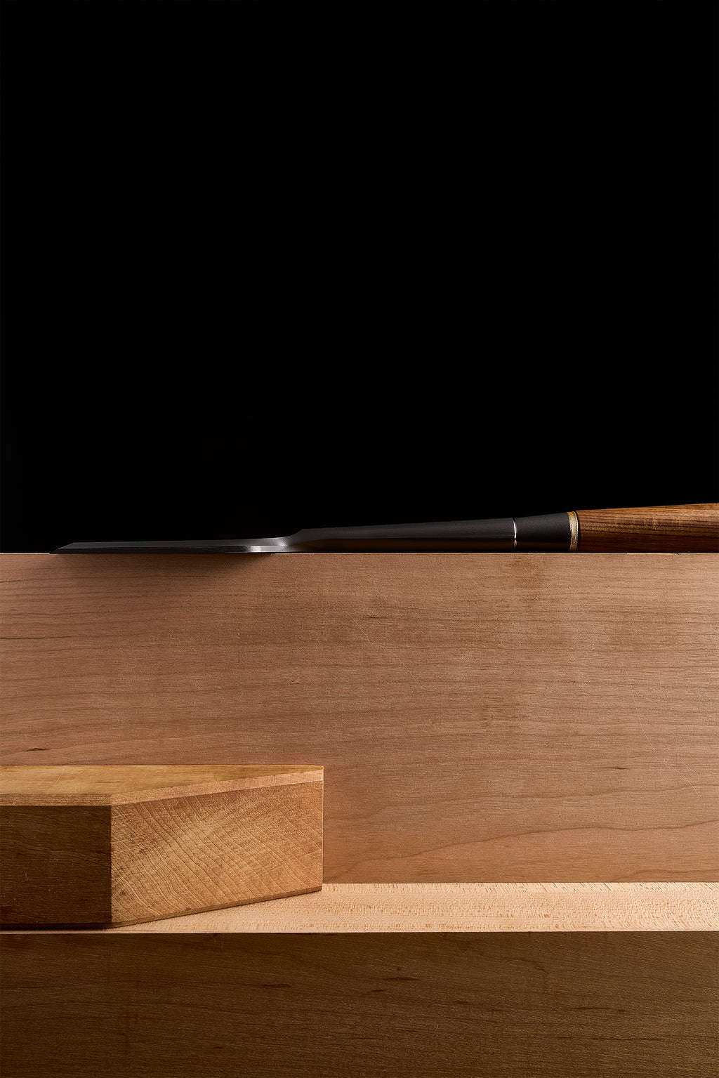 DC-1 paring chisel laid low along a bench, edge brought up to a block of wood