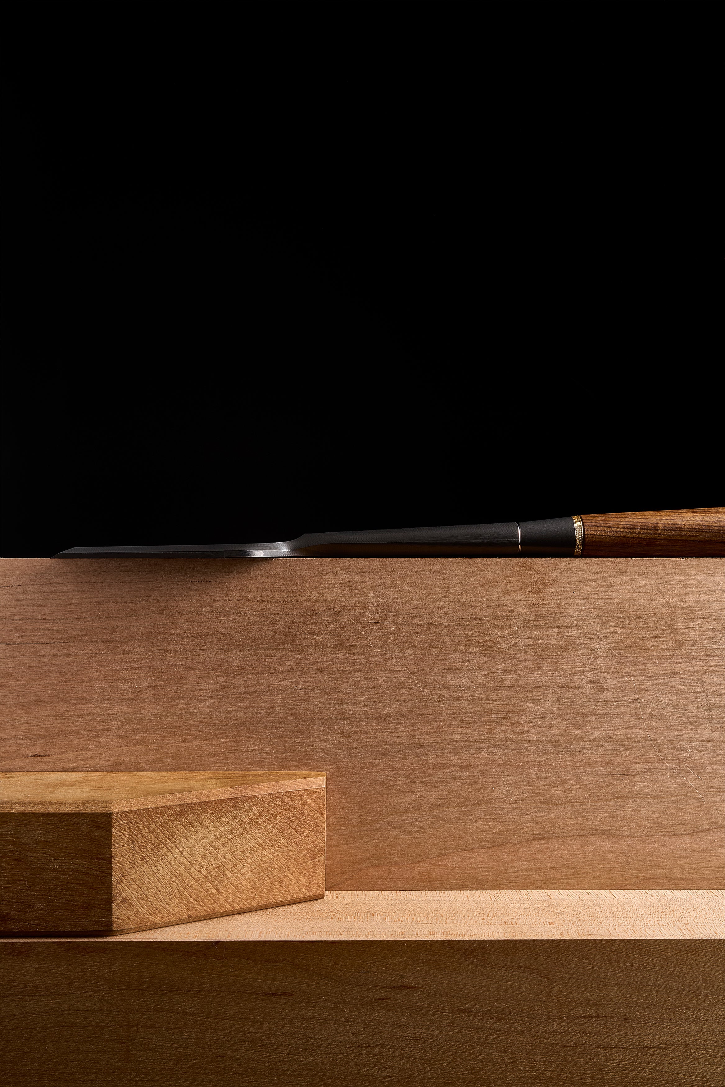 DC-1 paring chisel laid low along a bench, edge brought up to a block of wood