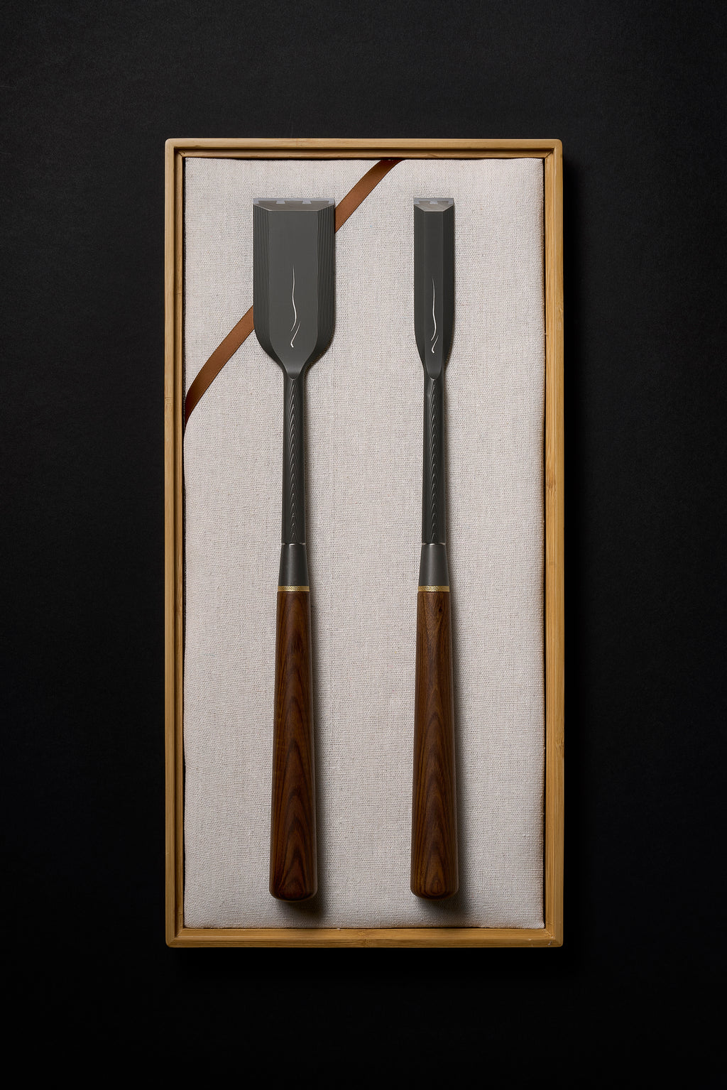 Zen-Wu DC-1 paring chisels, wide and narrow, titanium necks and jatoba handles, laid on linen in an open bamboo box