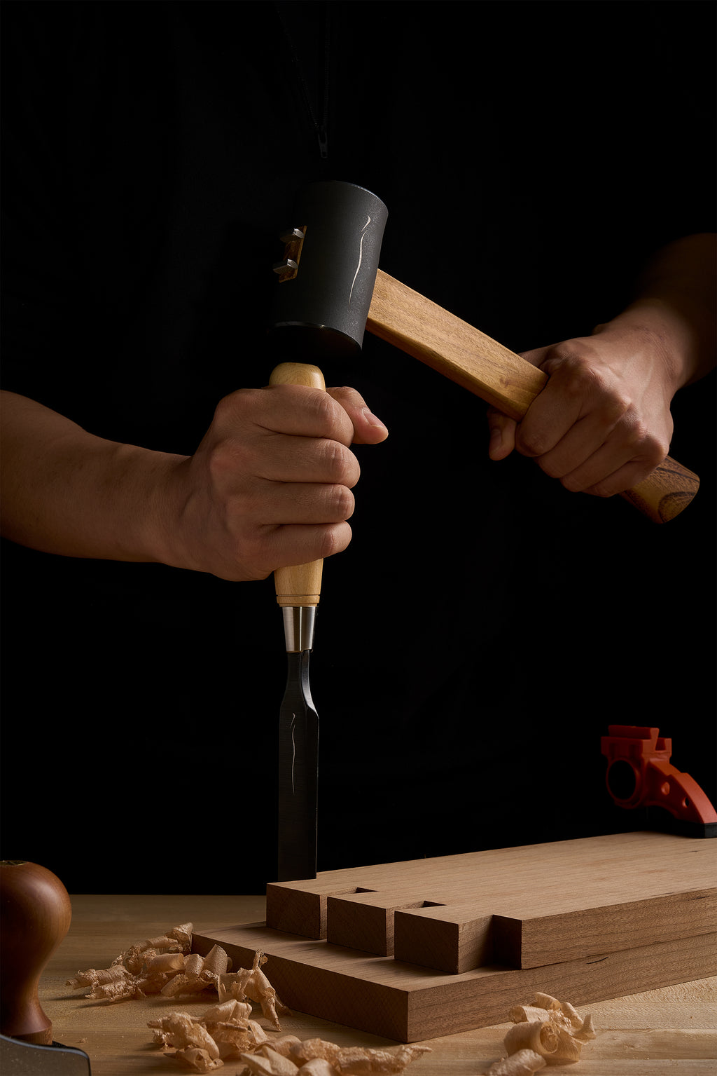 Driving a chisel with the Zen-Wu F-3 hammer at the bench, shavings around the work